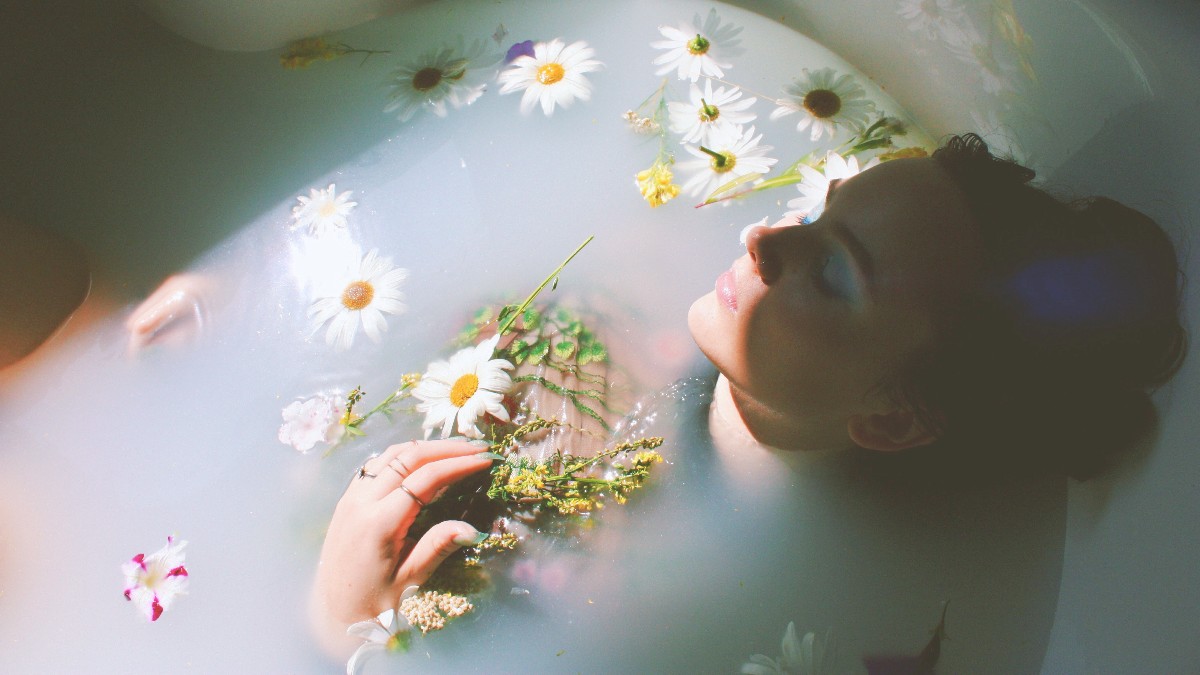 woman taking a bath with flowers in the water