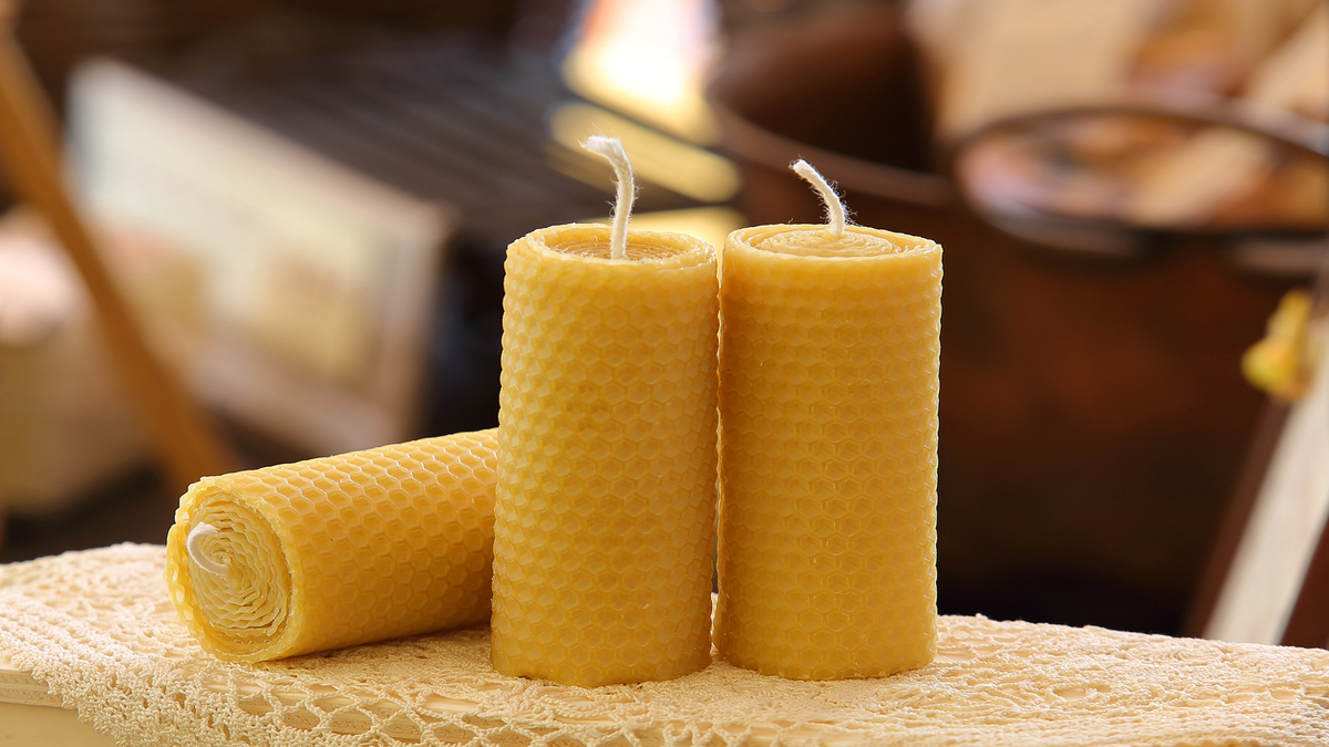 Artisanal eco-friendly candles in wax honeycombs with warm background
