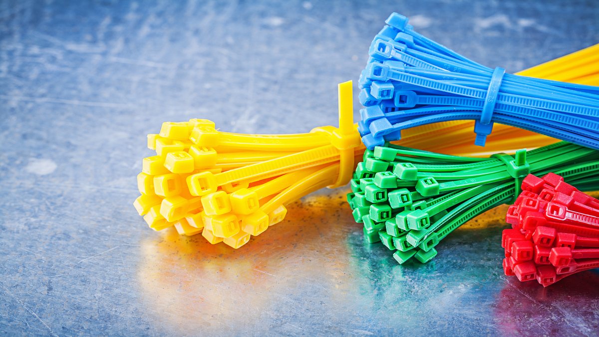 Multicolored plastic zip ties on metallic background