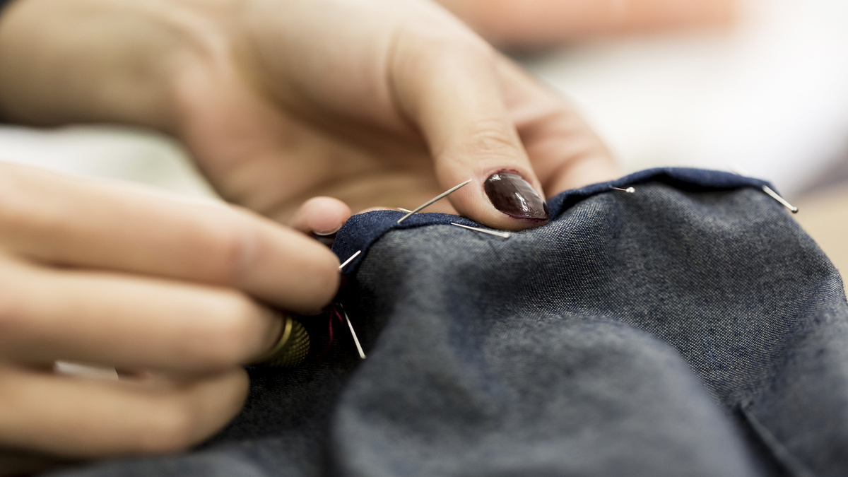 female fashion designer mend clothing