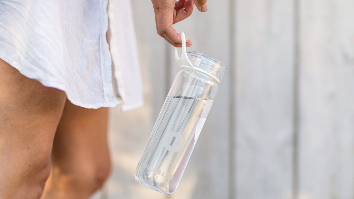 woman holding plastic reusable water bottle